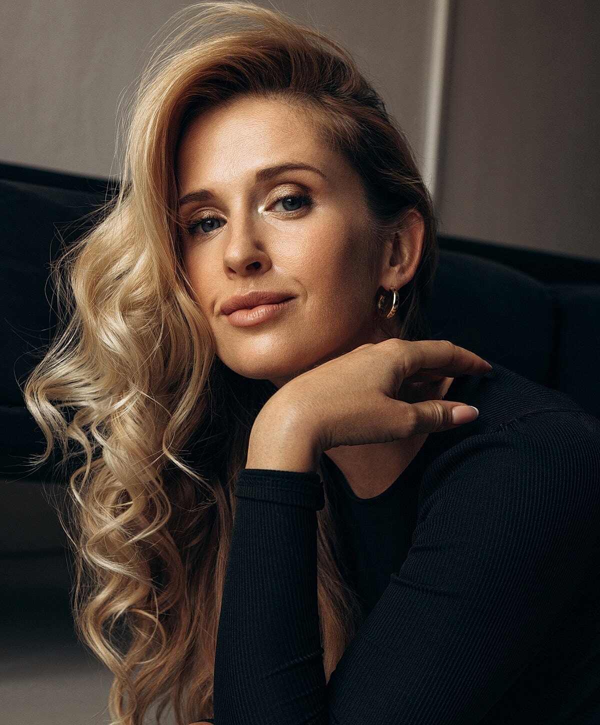 Model striking a pose against a textured wall.