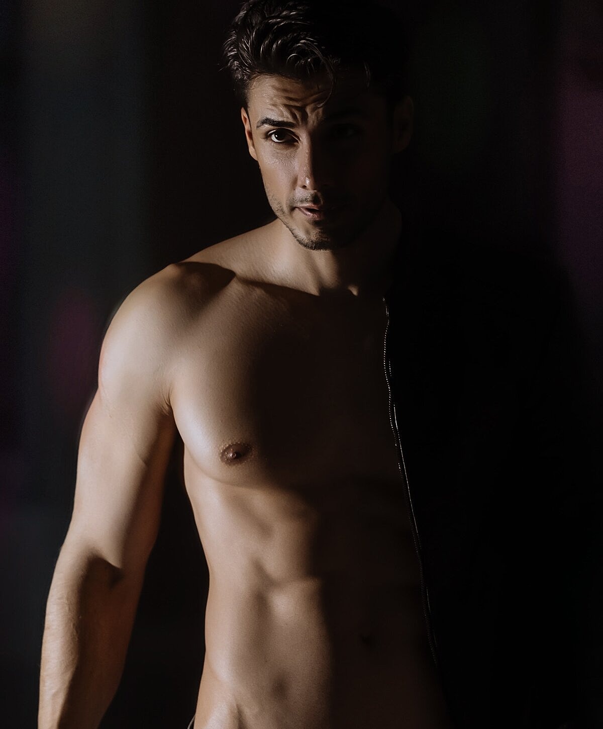 Model striking a pose against a textured wall.