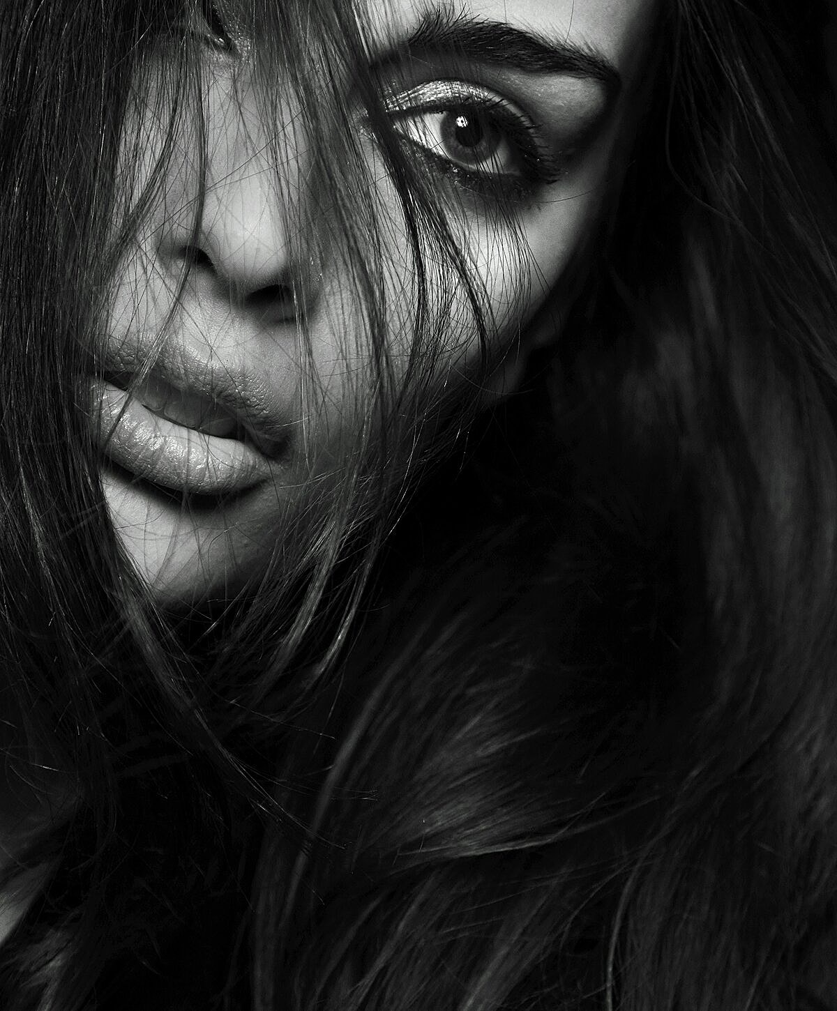 Woman's face partially illuminated by shadow.