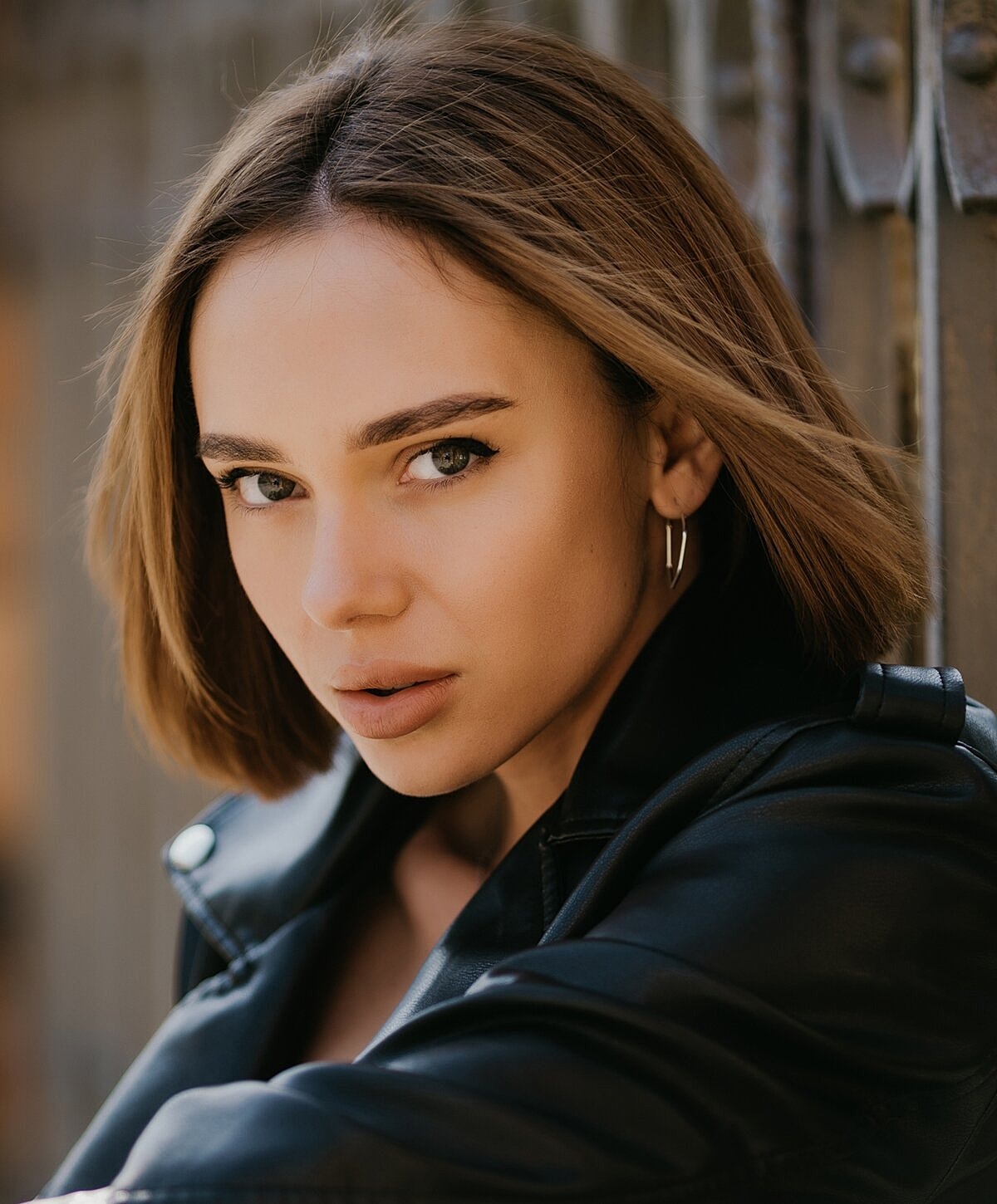 Model posing in neutral-colored lingerie against backdrop.