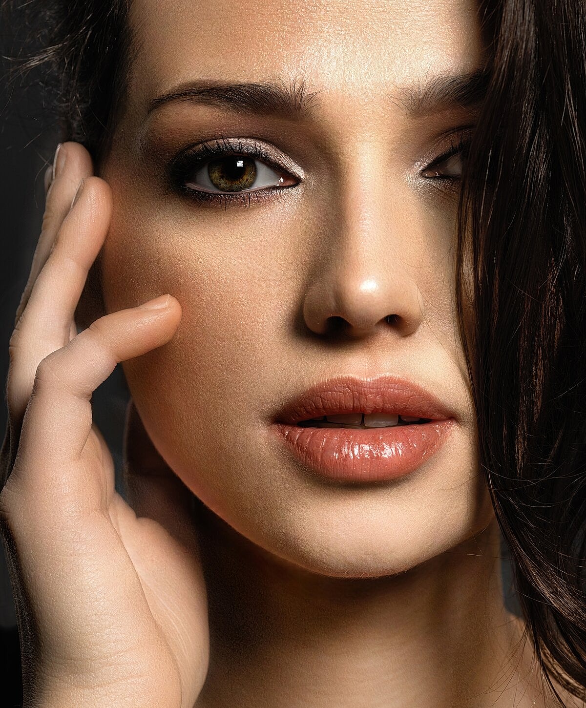 Model posing in neutral-colored lingerie against backdrop.