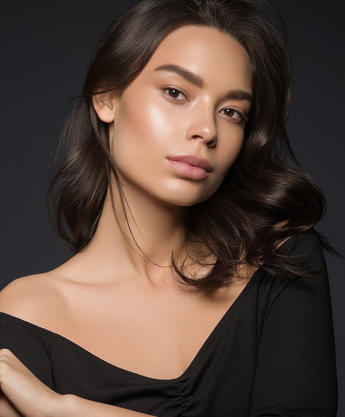 Model striking a pose against a textured wall.
