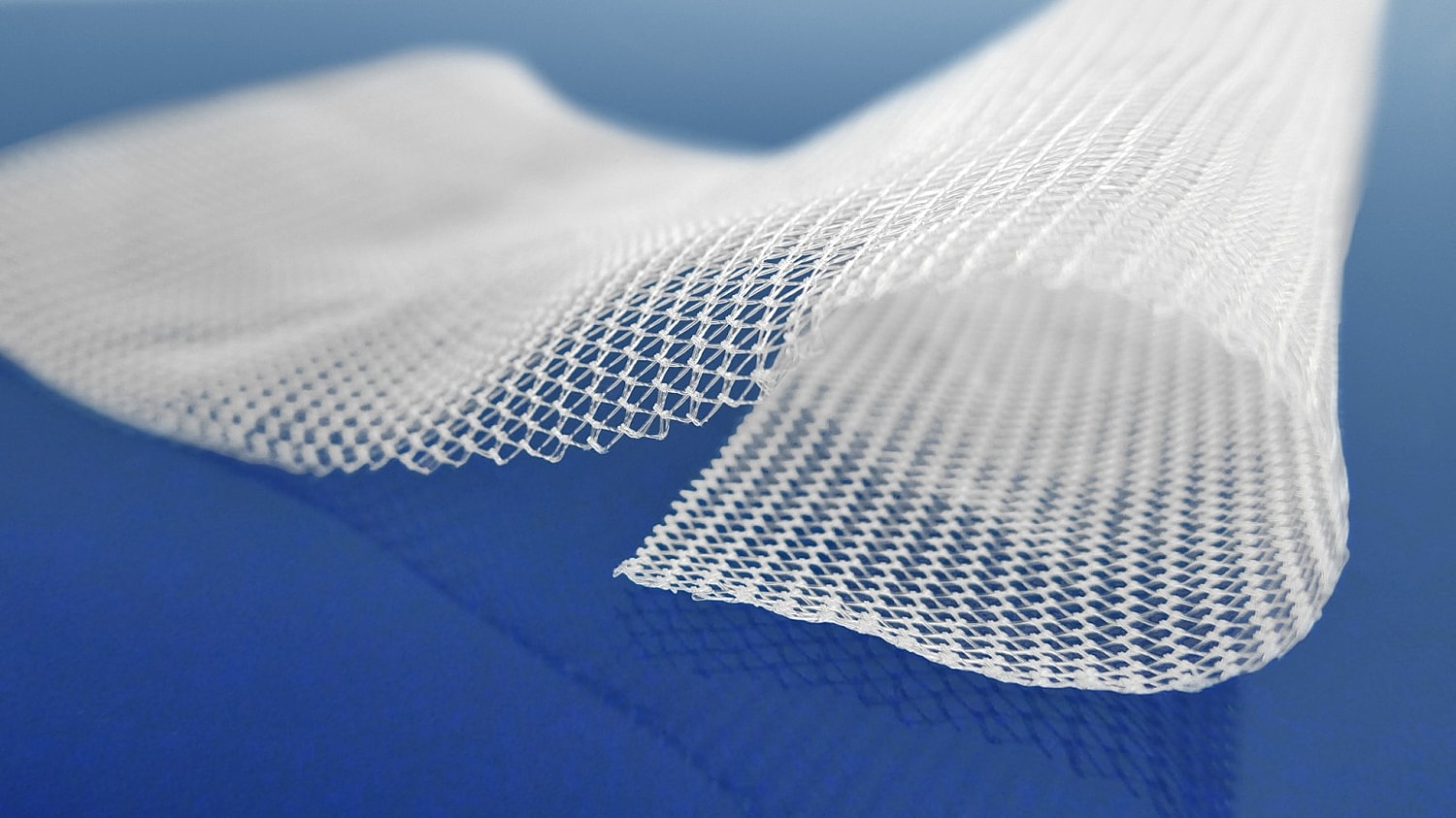 White mesh fabric on blue background.