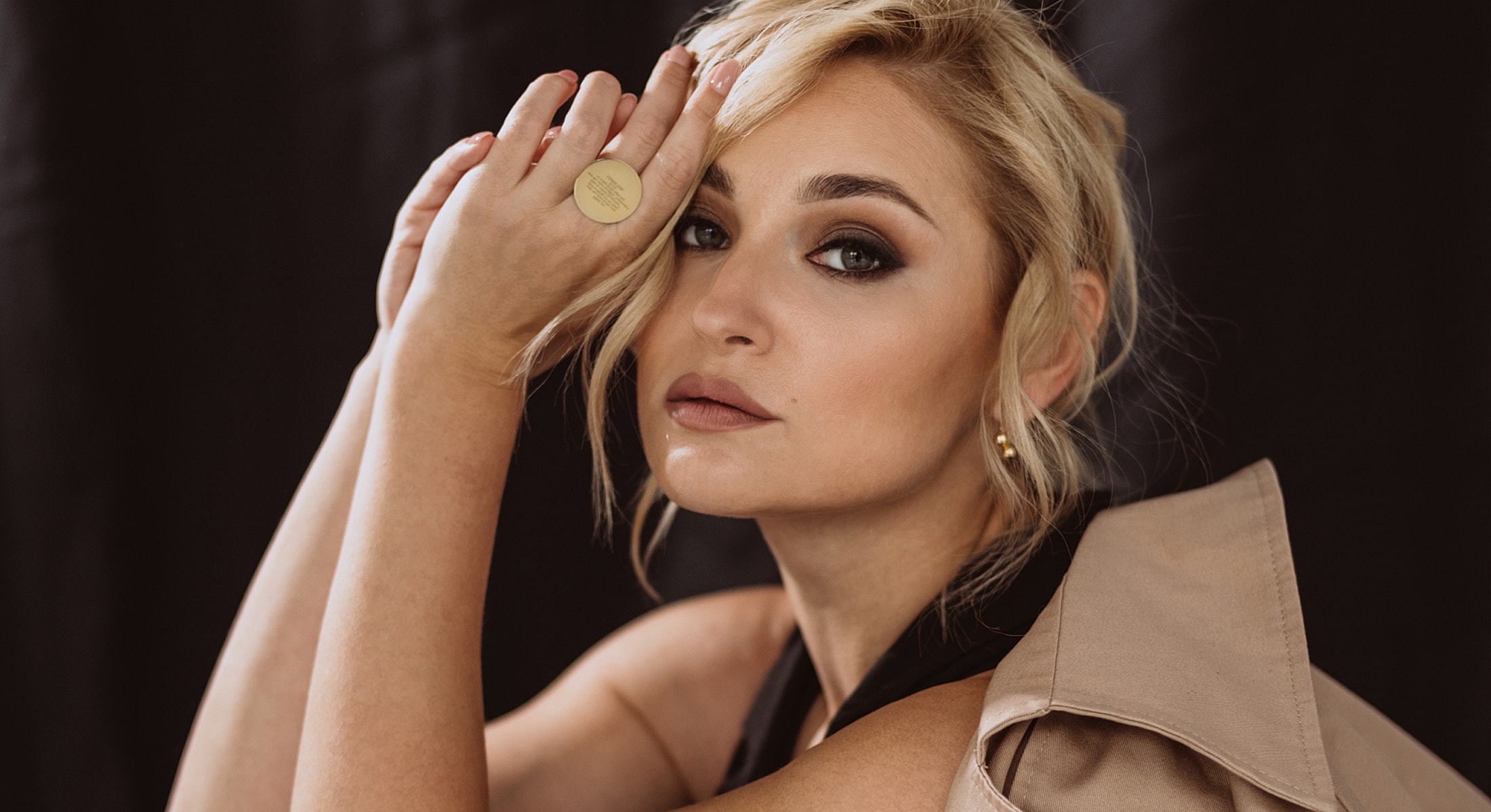 Woman posing elegantly with hand on face.