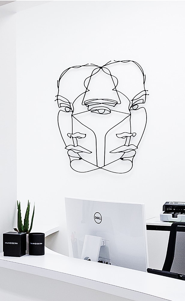 Wire sculpture of abstract human faces.