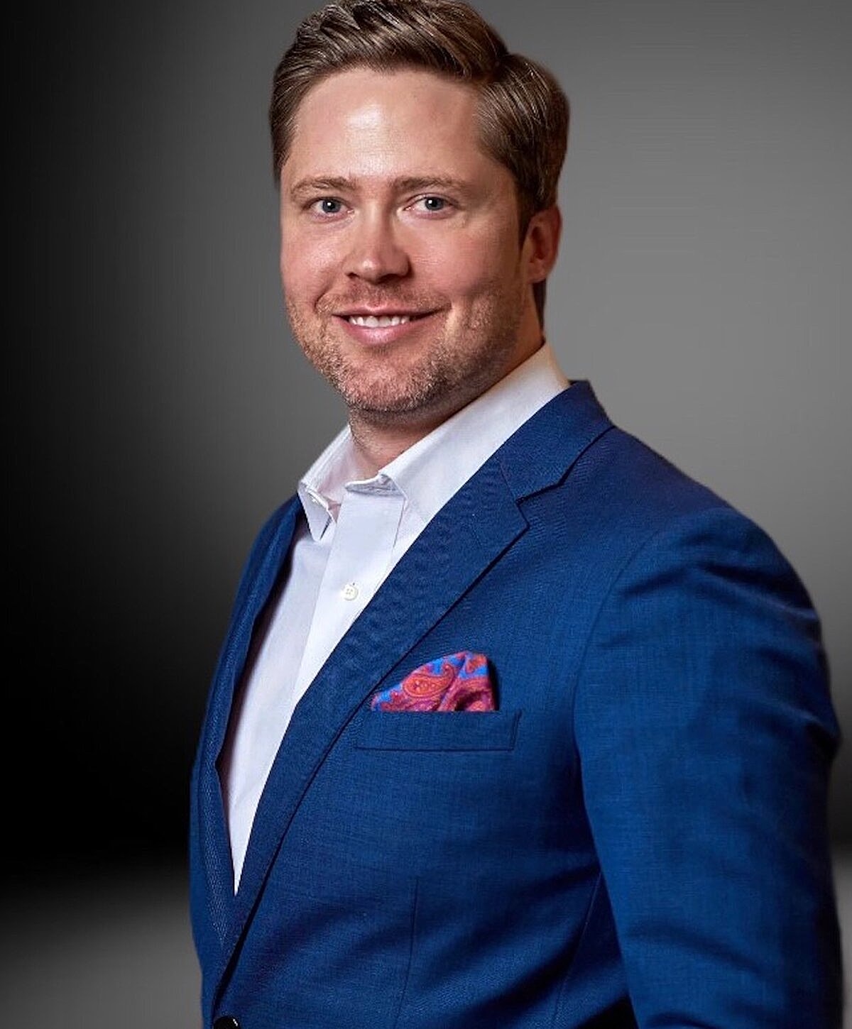 Smiling man in a blue suit jacket.