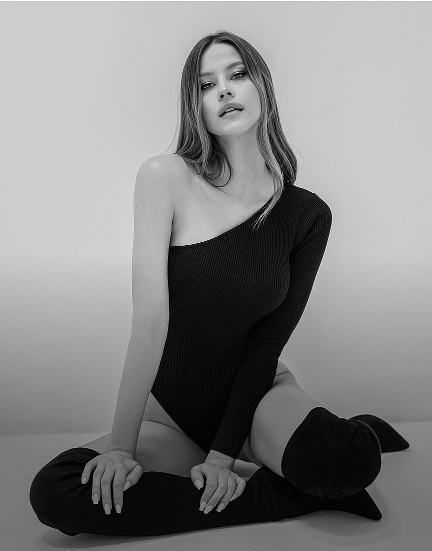 Woman in stylish outfit with dramatic lighting.